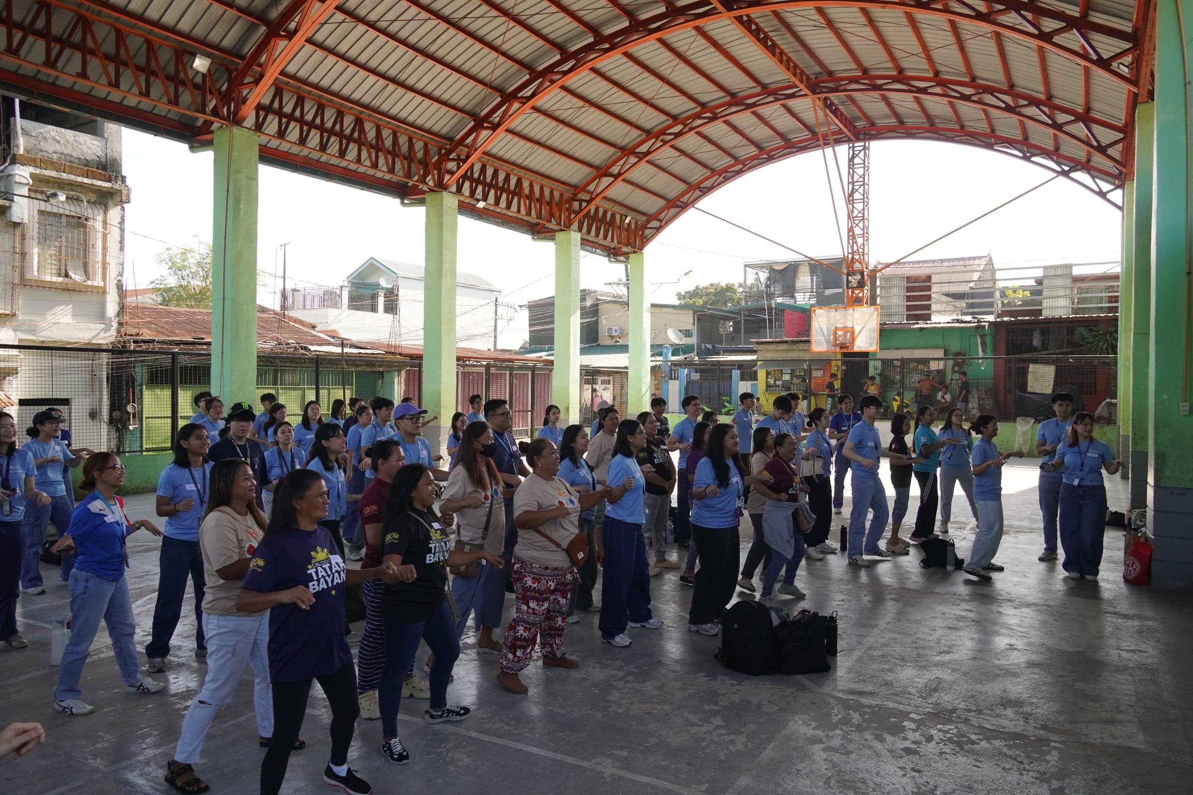 Members and community participants doing Zumba together in a covered court