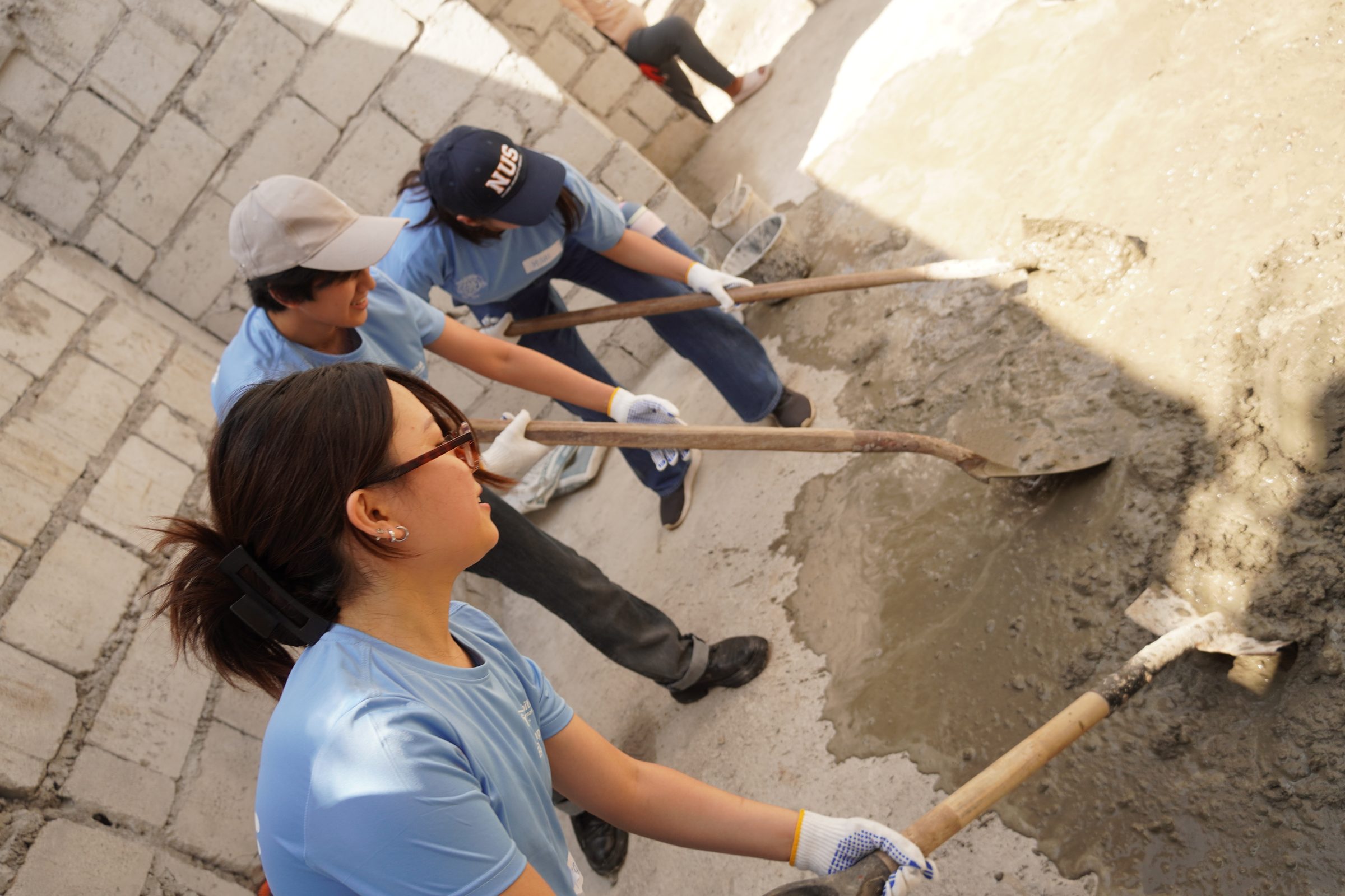 Members shovelling wet cement on site
